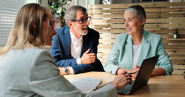 A man and woman speaking with an analyst, suggesting estate planning advice